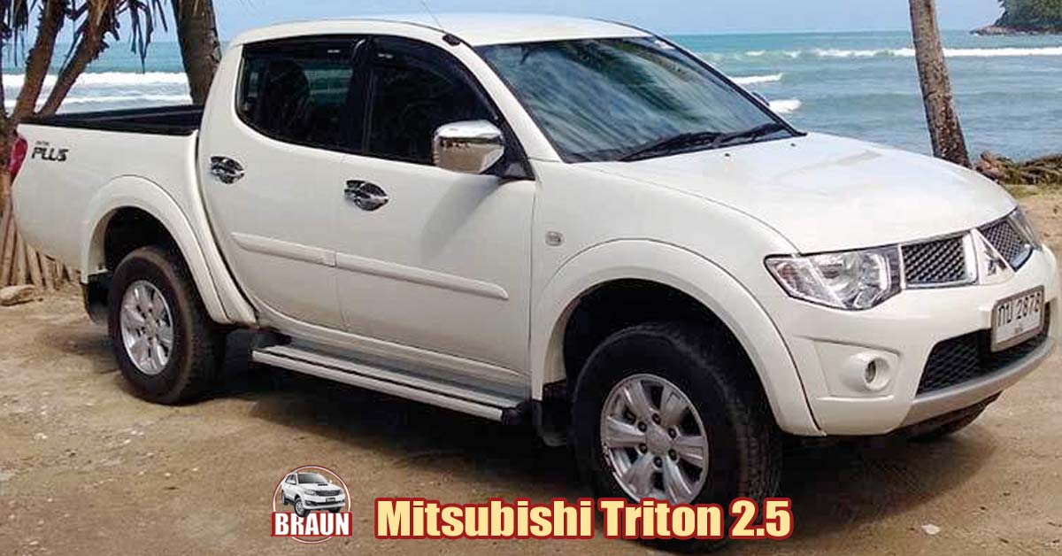white mitsubishi triton 2.5 litre pick up truck parked close the beach in ya nui, phuket a braun car rental logo shows it is on hire for the day for its trip to the beach