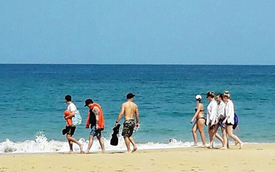 group of holiday makers on the beach at nai yang